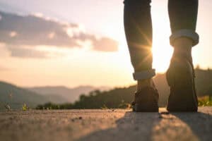 Person walking outdoors at sunset, promoting healt.