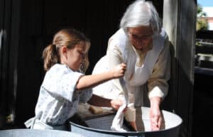 Woman and girl participating in a traditional craf.