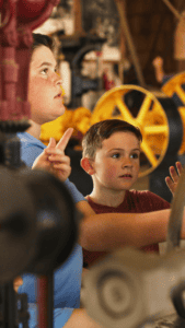 Children exploring vintage machinery at Florida St.