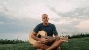 Man playing guitar outdoors at Florida State Fair.