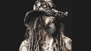 Man with long hair and tattoos wearing a patterned.