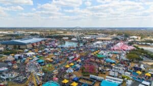 Crowd at Florida State Fairgrounds with rides and.